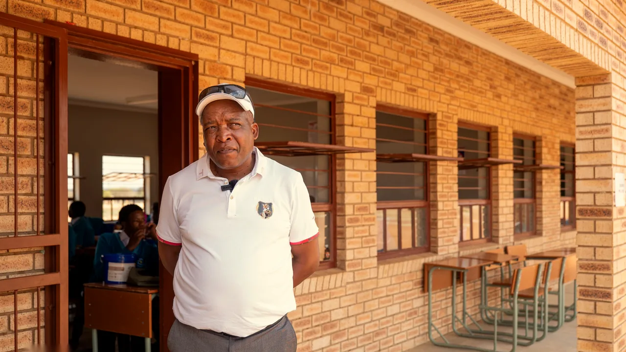 A man outside a classroom with learners seated inside